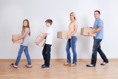 Movers carrying furniture through a narrow staircase in Chelsea